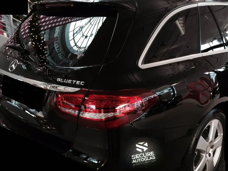 Schwarzer Kombi-SUV mit getönten Scheiben und Secure-Autoglas-Aufkleber am Heck